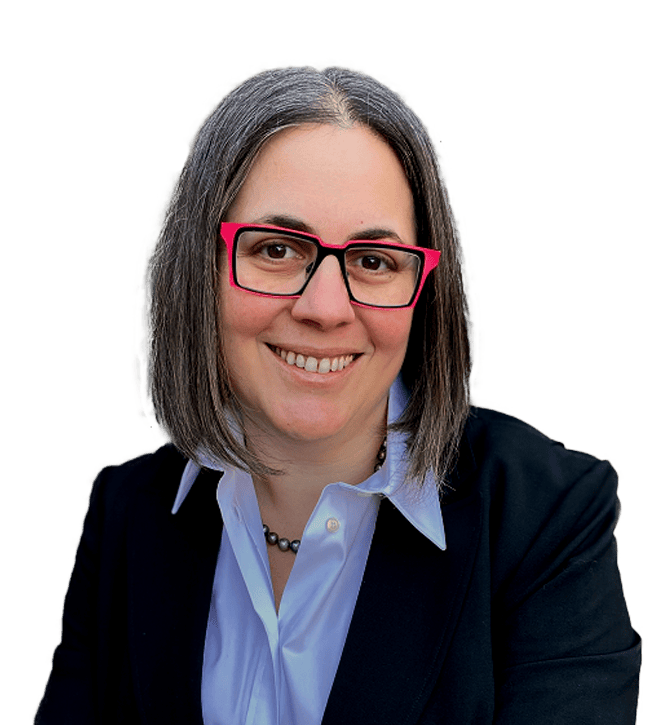 Smiling businesswoman with shoulder-length gray hair and pink glasses, wearing a blue shirt and black blazer.